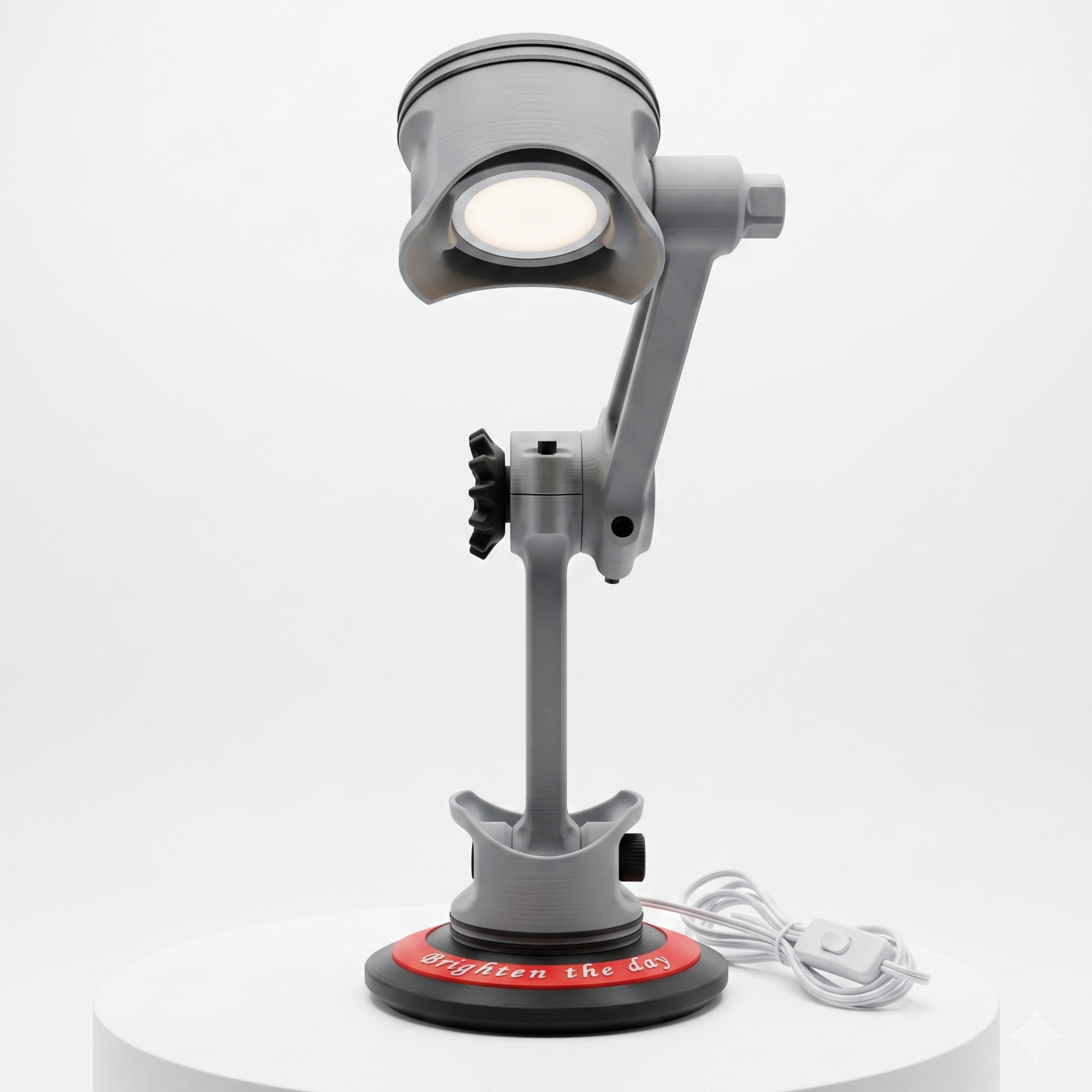 A gray adjustable desk magnifier lamp with a circular head, mounted on a stand with a red circular base, shown on a white cylindrical pedestal against a light gray background.